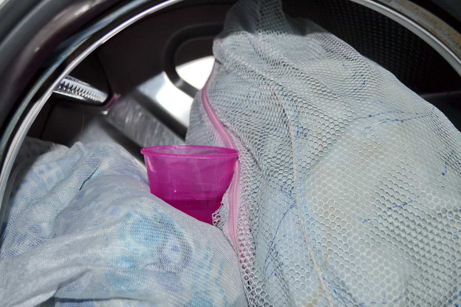 Загрузите подушки и моющие средства в барабан машины, а кондиционер в специальное отделение и запустите цикл.